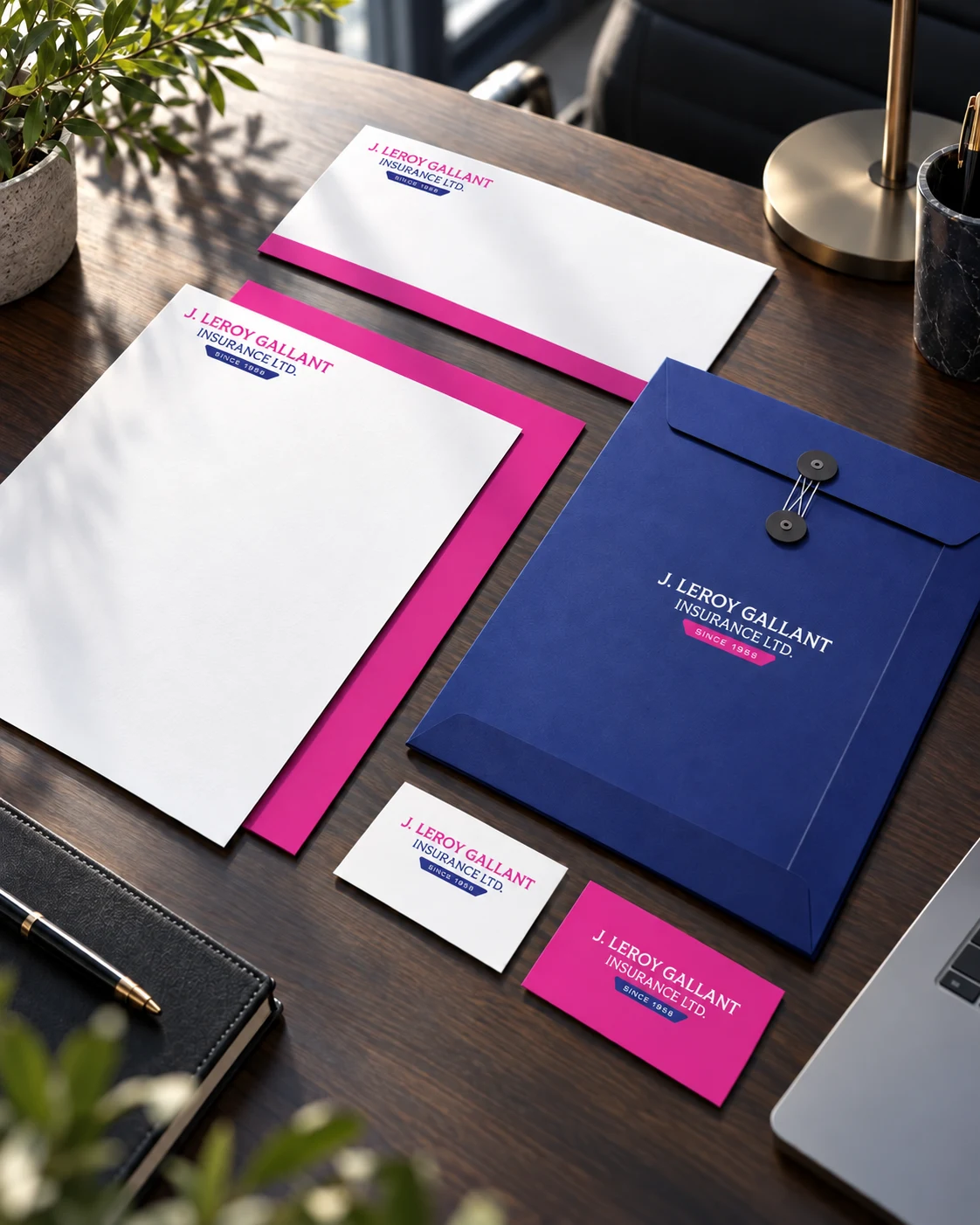 J. Leroy Gallant branded stationery, business cards and indigo presentation envelope together on an office desk